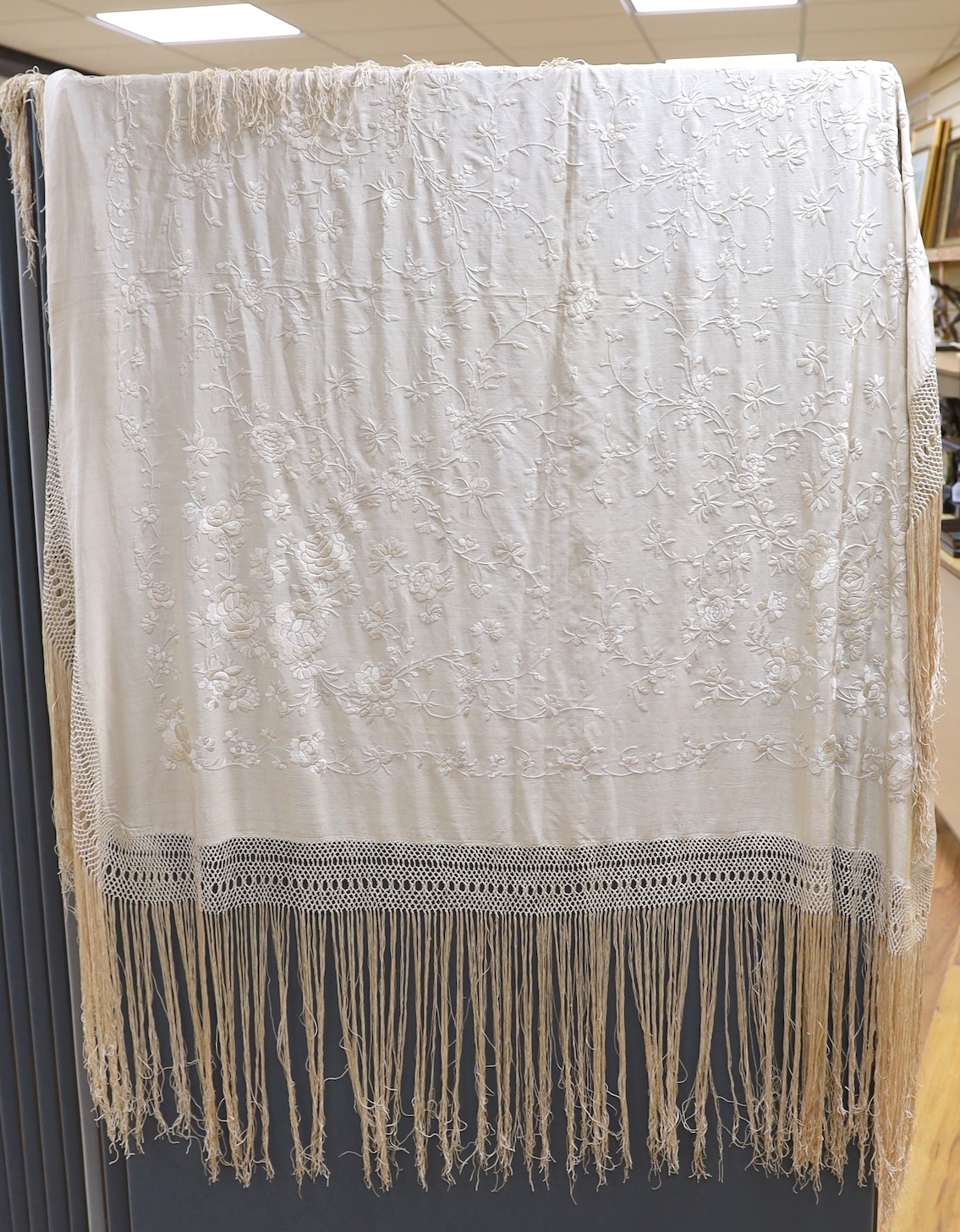 A Chinese late 19th century silk embroidered shawl, with cream on cream embroidery and a cream silk fringe, 140x134 cms